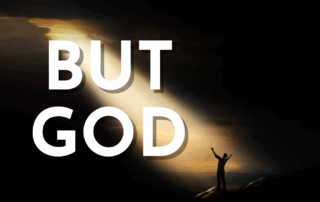 Man standing on a mountain with his arms raised up high to the sky with text that reads But God