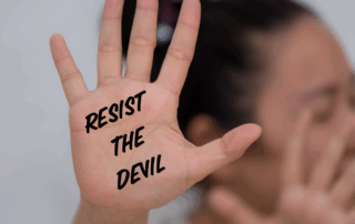Woman holding up both hands with the text resist the devil over the palm of her hand.