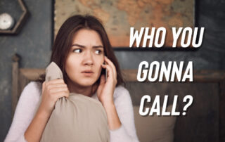 Scared woman on her phone while holding a pillow with white text Who You Gonna Call?